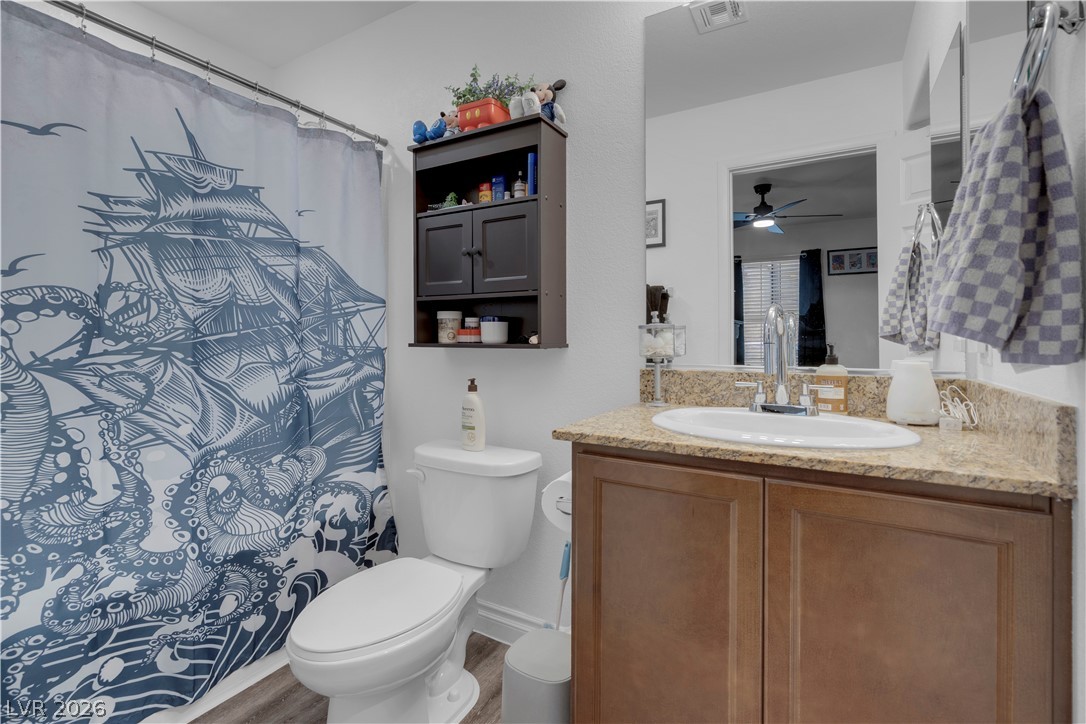 4536 Woolcomber Street Las Vegas, NV 89115 - Photo 12 of 34 Bathroom featuring vanity, curtained shower, and wood finished floors