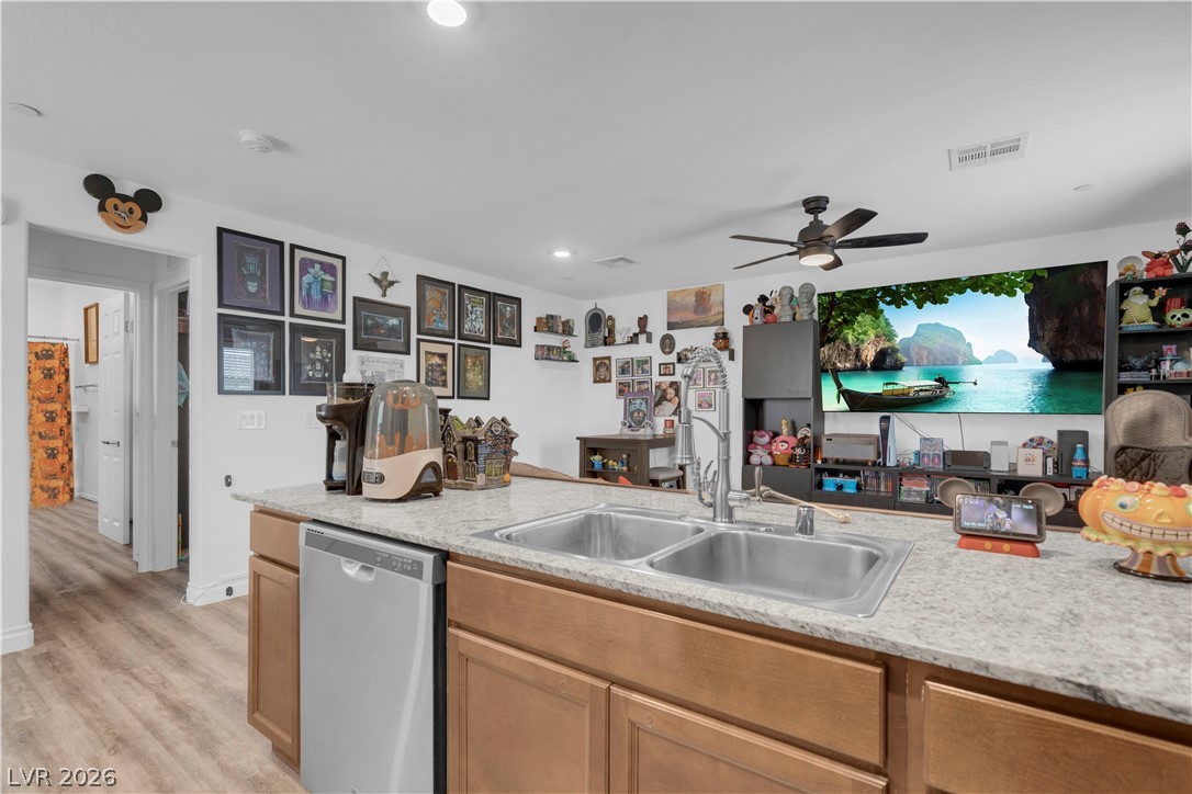 4536 Woolcomber Street Las Vegas, NV 89115 - Photo 34 of 34 Kitchen featuring light countertops, stainless steel dishwasher, light wood-style flooring, recessed lighting, and open floor plan