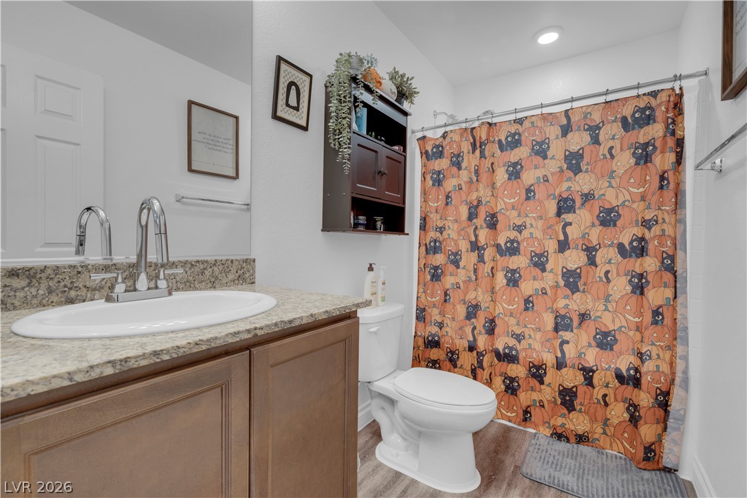 4536 Woolcomber Street Las Vegas, NV 89115 - Photo 26 of 34 Bathroom featuring vanity, a shower with shower curtain, and light wood-style flooring