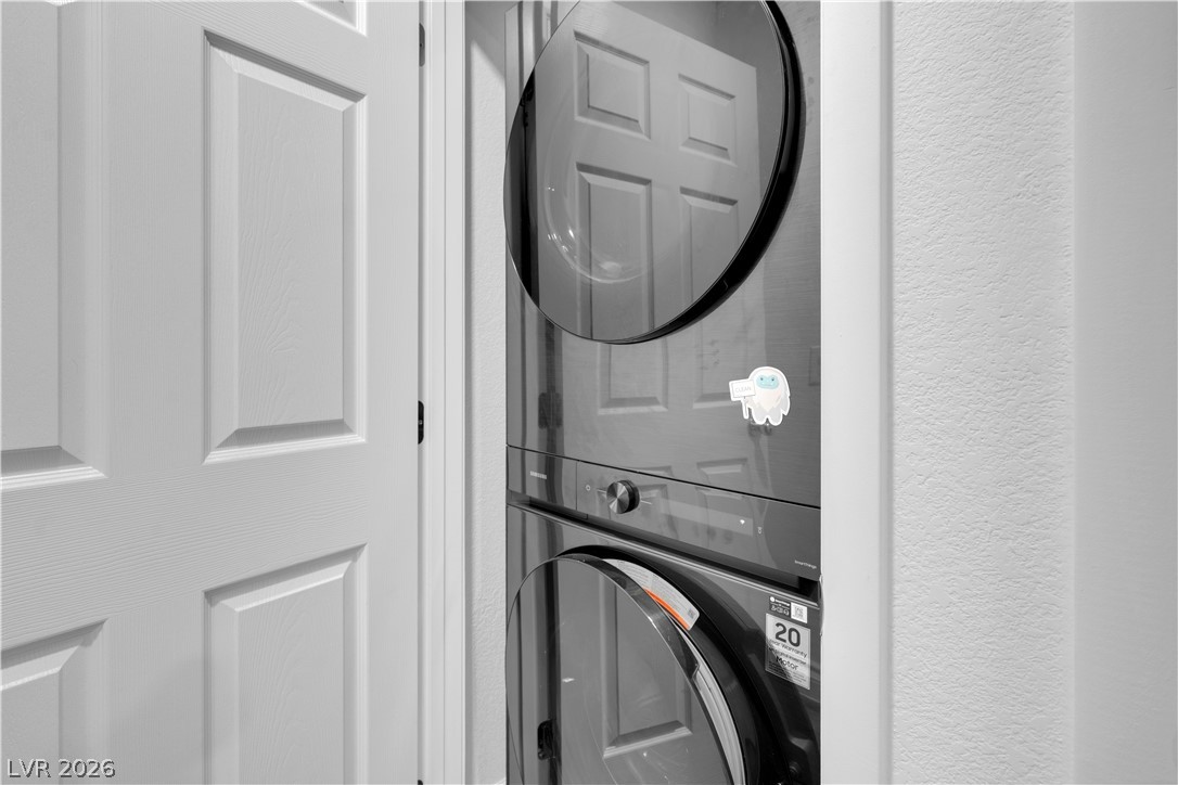 4536 Woolcomber Street Las Vegas, NV 89115 - Photo 27 of 34 Laundry area featuring a textured wall and stacked washer and clothes dryer