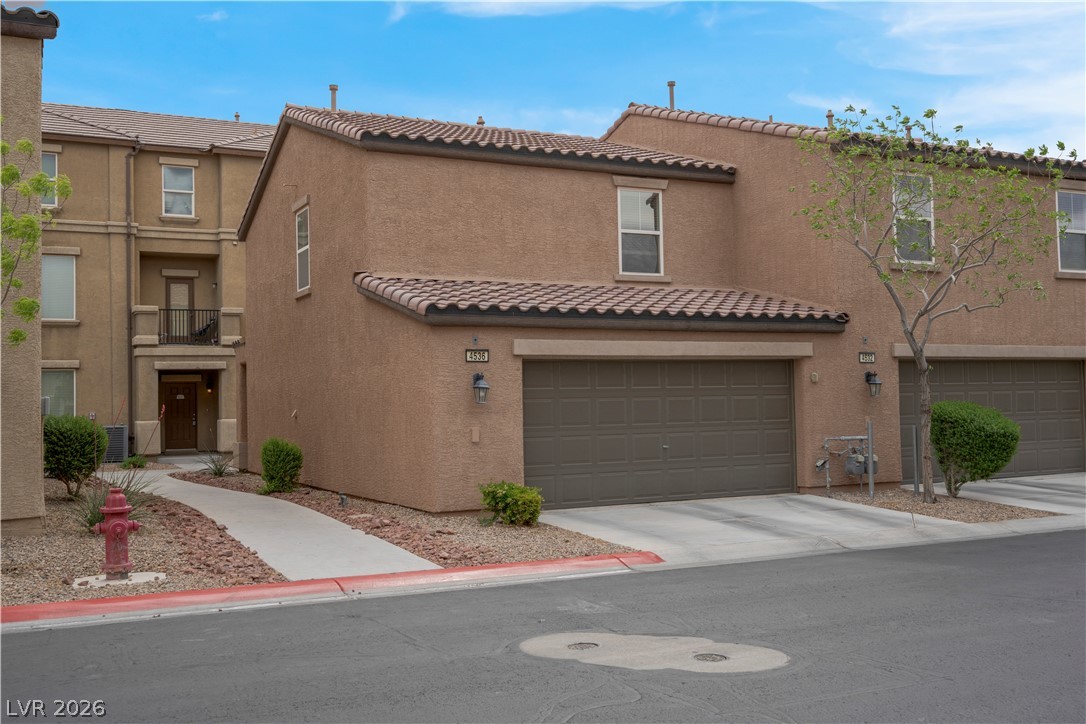 4536 Woolcomber Street Las Vegas, NV 89115 - Photo 3 of 34 View of front of home with a garage, a balcony, and stucco siding