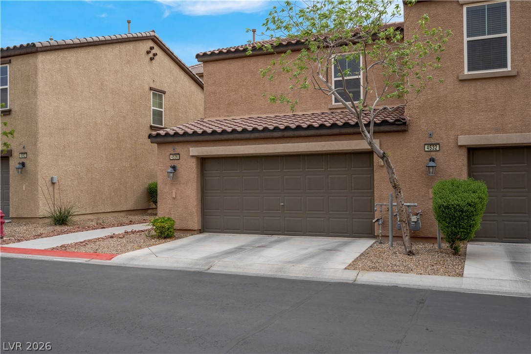 4536 Woolcomber Street Las Vegas, NV 89115 - Photo 5 of 34 Mediterranean / spanish-style home with a tile roof, stucco siding, and concrete driveway