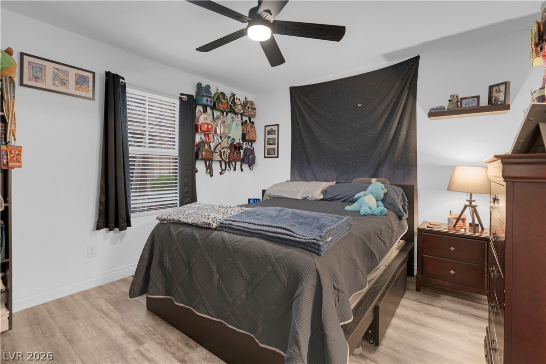 4536 Woolcomber Street Las Vegas, NV 89115 - Photo 8 of 34 Bedroom with light wood-style floors and ceiling fan