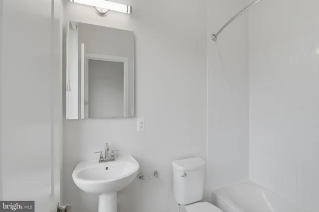 a bathroom with a sink a toilet and mirror