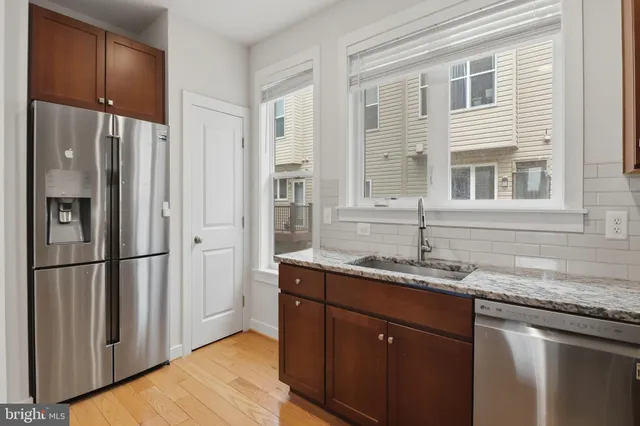 a kitchen with stainless steel appliances granite countertop a refrigerator and a sink