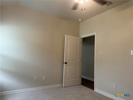 an empty room with chandelier fan