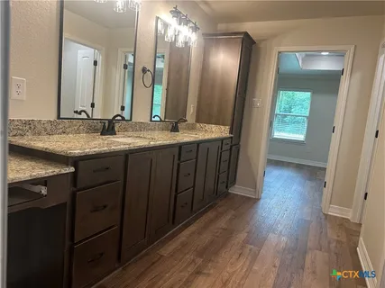 a bathroom with a granite countertop sink and a mirror