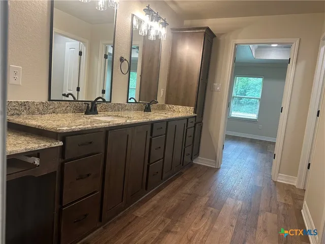 a bathroom with a granite countertop sink and a mirror