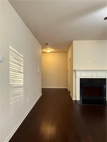 a view of empty room with wooden floor and fireplace