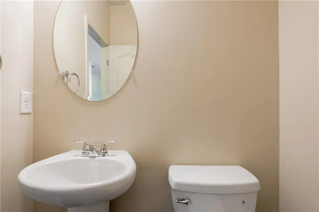 a bathroom with a toilet a sink and a mirror