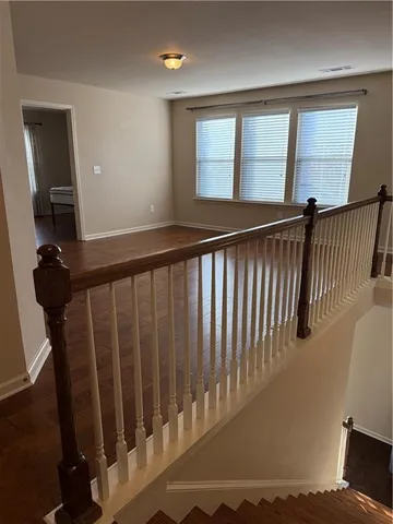 a view of a hallway with wooden floor and windows