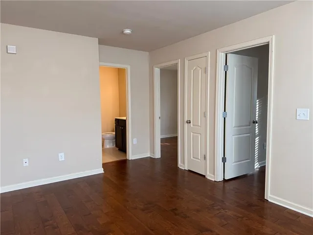 an empty room with wooden floor and closet