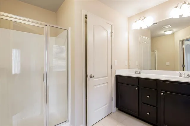 a bathroom with a double vanity sink and mirror with shower