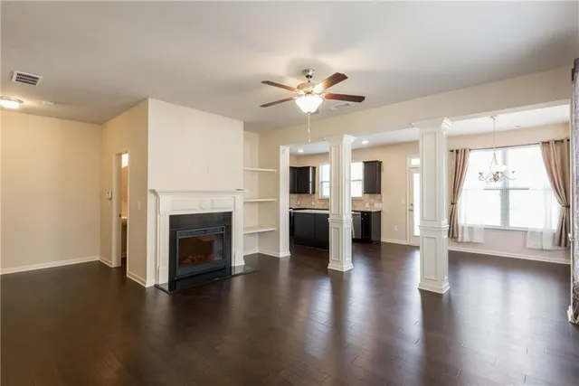 a view of a livingroom with a ceiling fan fireplace and wooden floor