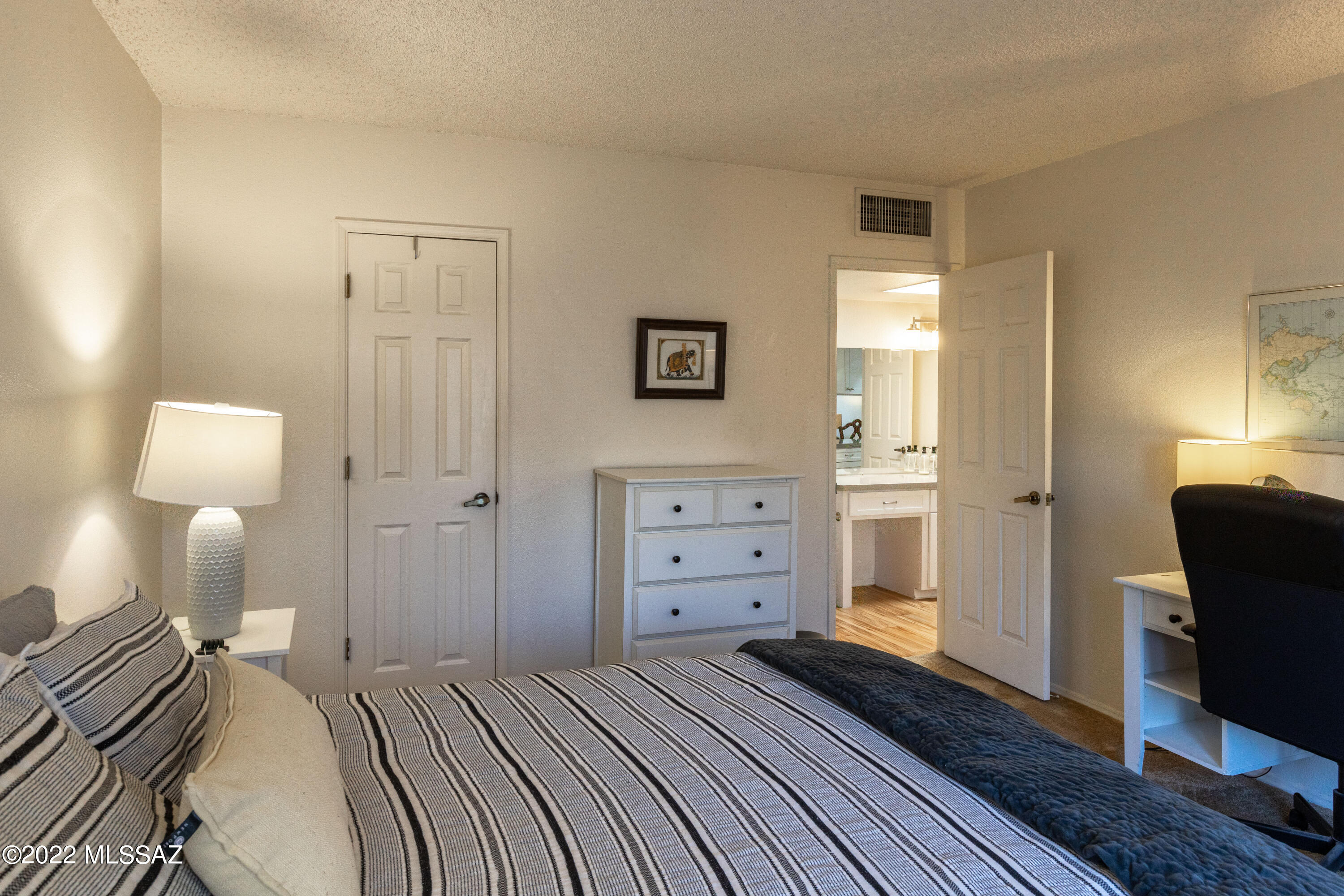 1200 East River Road, Unit F69 Tucson, AZ 85718 - Photo 13 of 22 a bedroom with a bed and wooden floor