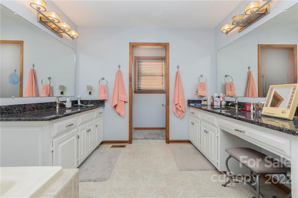4414 Hunter Rhyne Road Lincolnton, NC 28092 - Photo 24 of 35 a spacious bathroom with a granite countertop sink a mirror and a bathtub