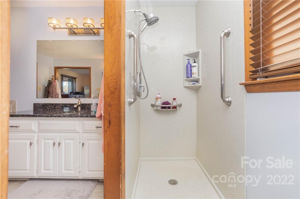 4414 Hunter Rhyne Road Lincolnton, NC 28092 - Photo 25 of 35 a bathroom with a granite countertop sink a mirror and a shower