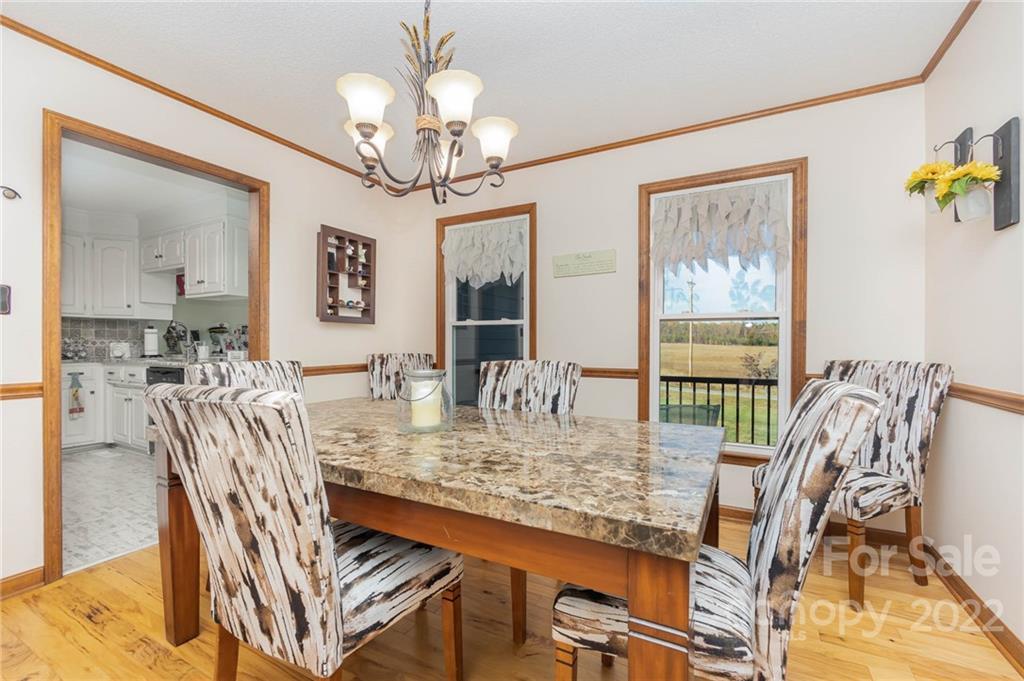 4414 Hunter Rhyne Road Lincolnton, NC 28092 - Photo 10 of 35 a view of a dining room with furniture a chandelier and wooden floor