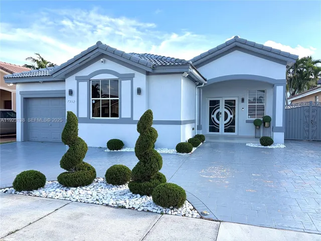 a front view of a house with potted plants