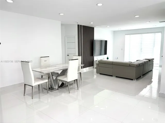 a living room with fireplace furniture and a large window