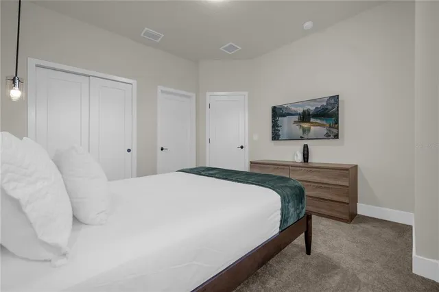 a large bed sitting in a bedroom next to a window