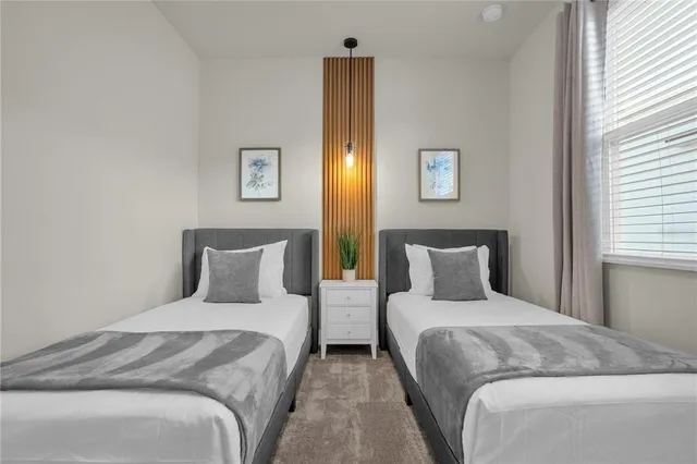 a bedroom with two beds and painting on the wall