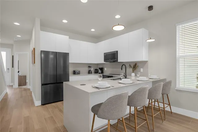 a kitchen with refrigerator and chairs