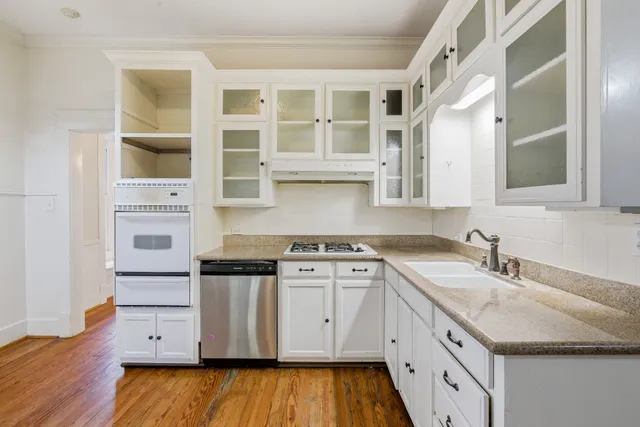 a kitchen with stainless steel appliances granite countertop white cabinets sink and stove