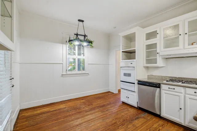a kitchen with stainless steel appliances granite countertop a stove and a wooden floors