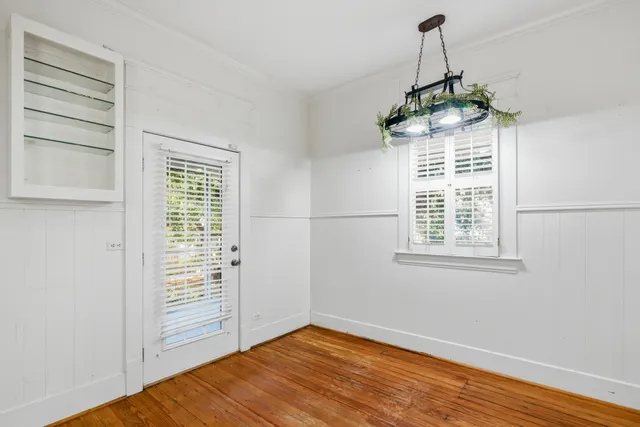 an empty room with windows & cabinet