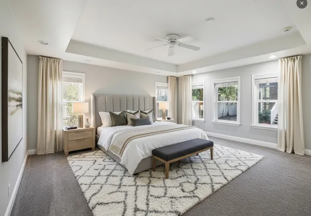 a spacious bedroom with a bed and glass window