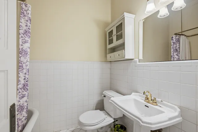 a white toilet sitting next to a bathroom sink