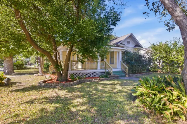 a view of a house with a tree and a yard