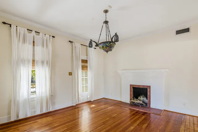a view of empty room with wooden floor and fireplace