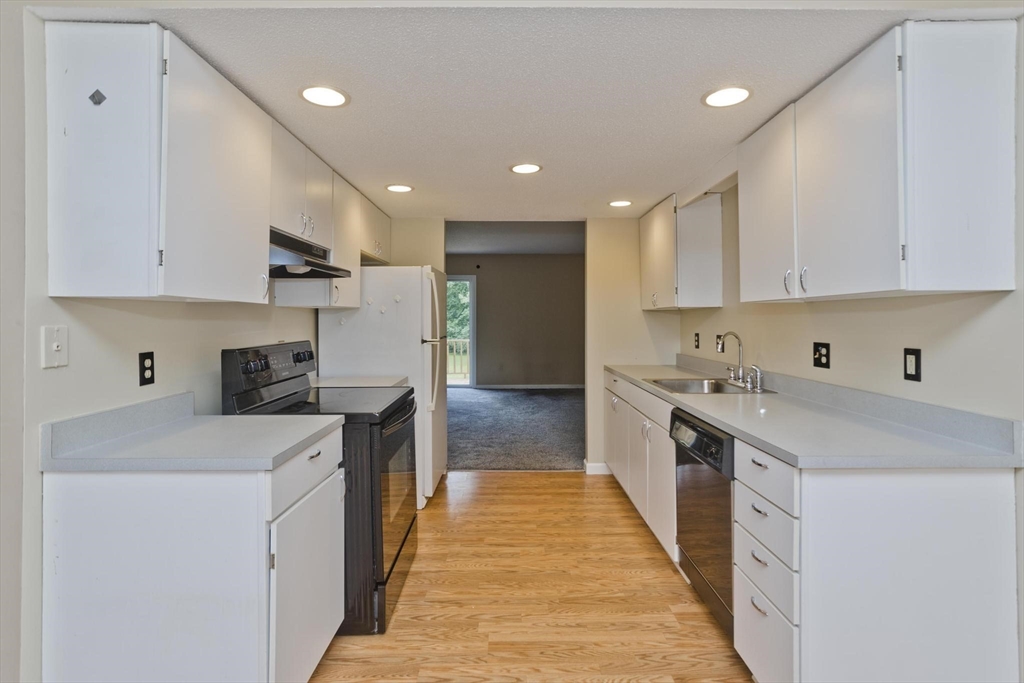610 County Road, Unit 7 Holyoke, MA 01040 - Photo 2 of 24 a kitchen with stainless steel appliances sink stove and white cabinets