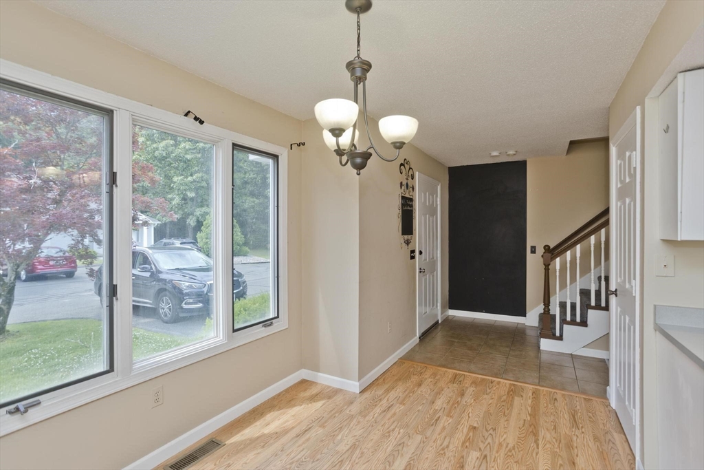610 County Road, Unit 7 Holyoke, MA 01040 - Photo 8 of 24 a view of a hallway with wooden floor and a chandelier