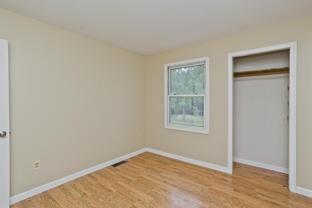 610 County Road, Unit 7 Holyoke, MA 01040 - Photo 10 of 24 an empty room with window and wooden floor