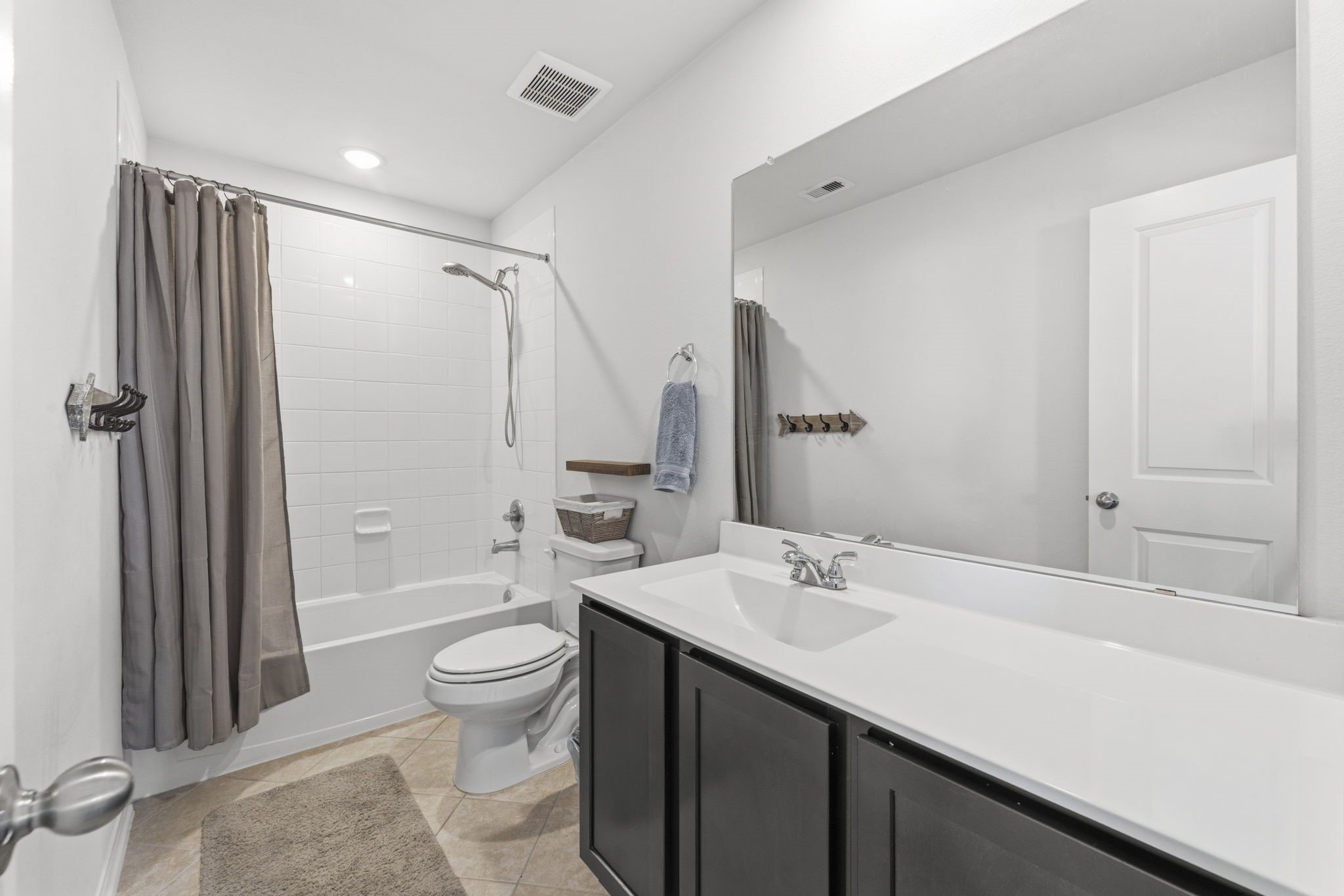 2401 Abbot Brk Drive Rosharon, TX 77583 - Photo 33 of 50 The third full bath serving Bedrooms 3 and 4 is thoughtfully appointed with stylish tile flooring laid on the diagonal, creating an elevated designer feel. An extended vanity with a sleek solid-surface countertop and integrated rectangular sink provides generous space and functionality, while the tiled shower/tub combination with a detachable handheld shower head offers both comfort and convenience for family and guests alike.