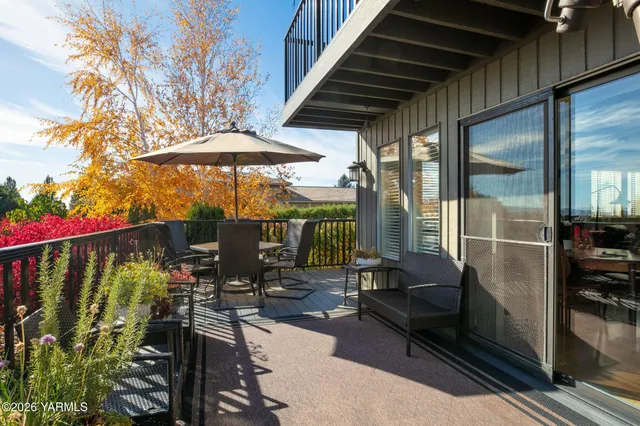 a view of balcony with furniture and umbrella