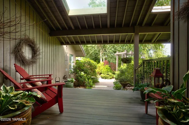 a backyard of a house with wooden floor potted plants and outdoor seating