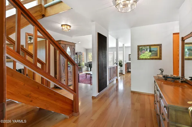 a view of a hallway with wooden floor and staircase