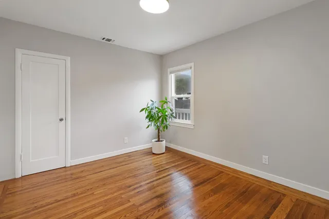 a view of a big room with wooden floor and windows