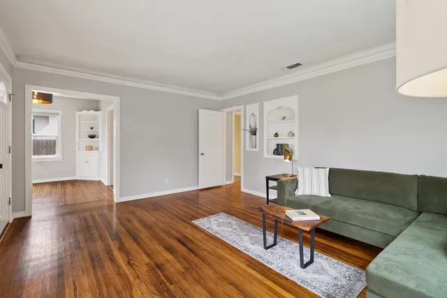 a view of an empty room with window and wooden floor
