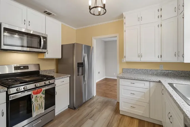 a view of a hallway with wooden floor and furniture