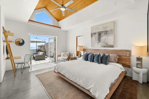 a large bedroom with a bed and glass walk in closet