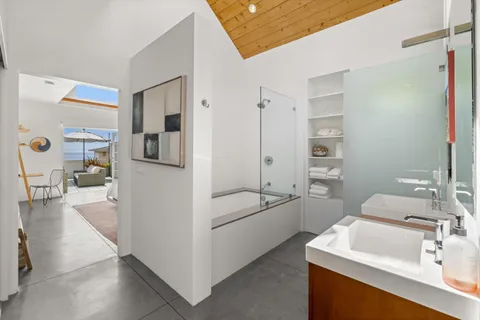 a bathroom with a tub sink and mirror