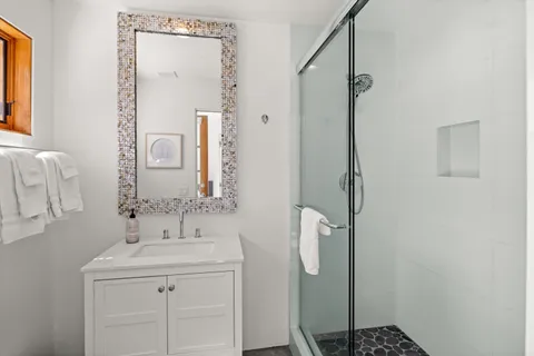 a bathroom with a sink a mirror and a shower