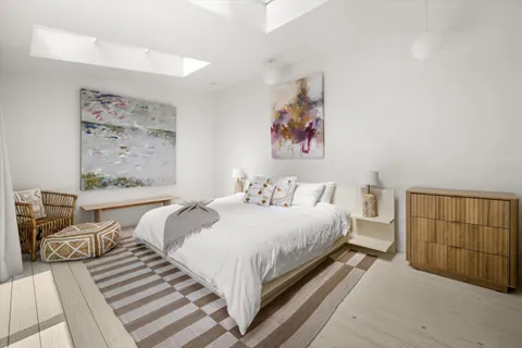 a bedroom with a bed and a painting on the wall