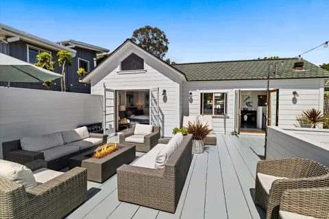 a view of a patio with couches table and chairs with wooden floor