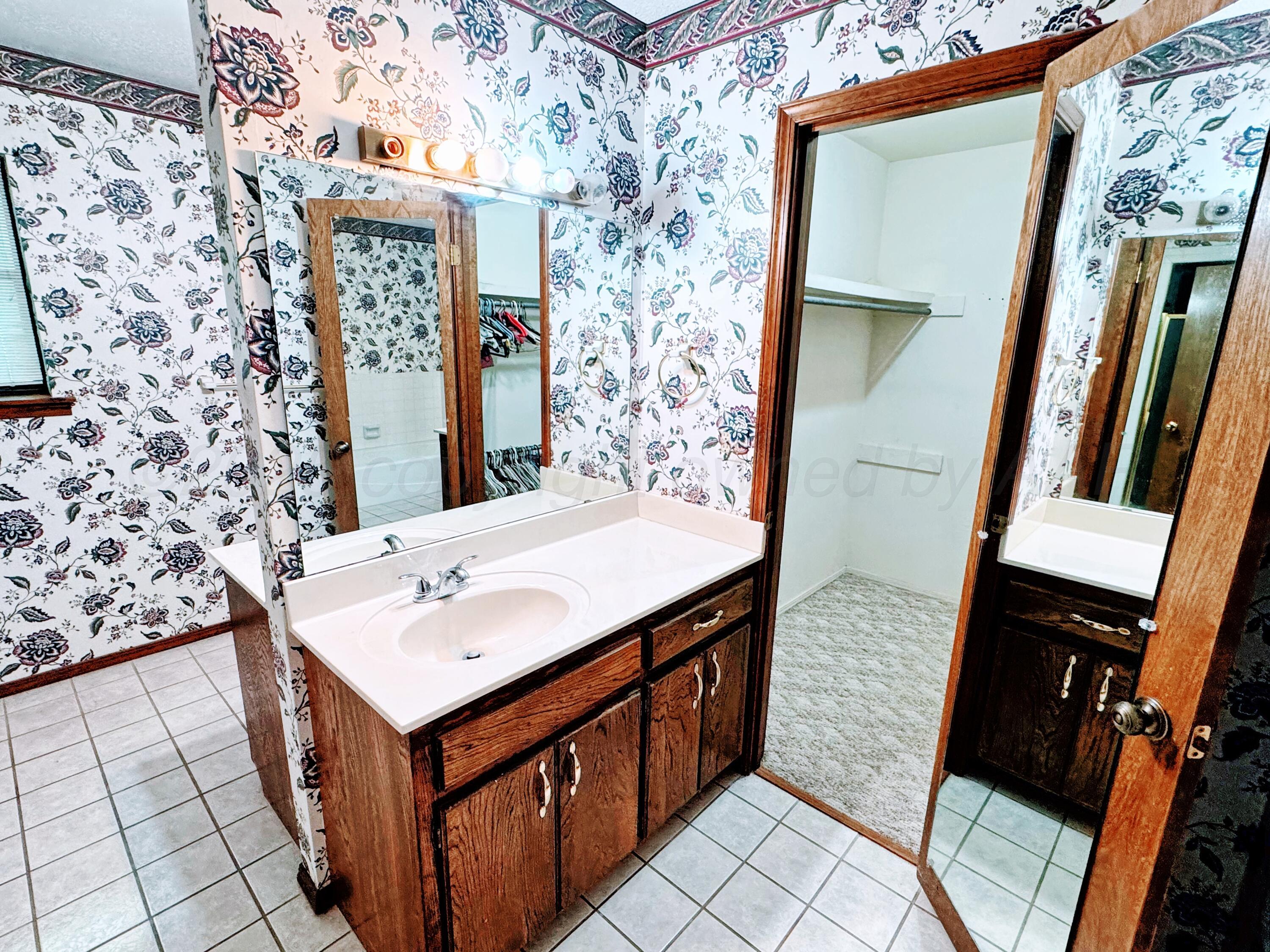 1905 Utah Street Perryton, TX 79070 - Photo 14 of 22 a bathroom with a sink a mirror and shower